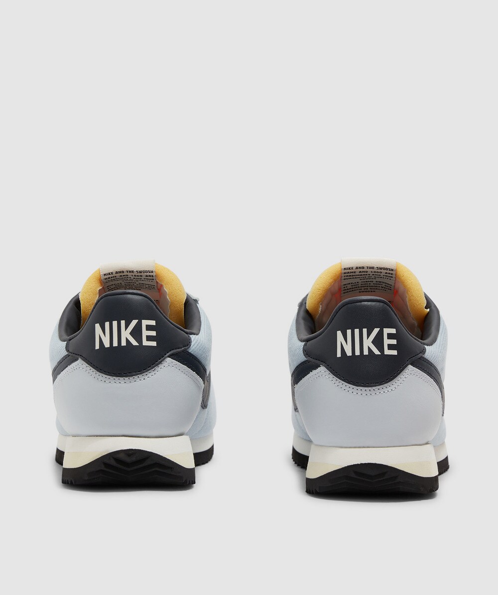 black nike cortez with gold swoosh